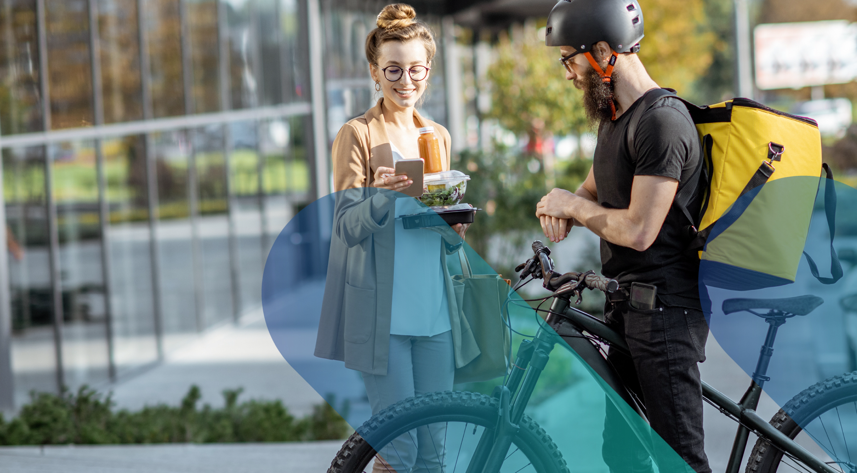 Food delivery courier handing over an order to a smiling woman outside a building.